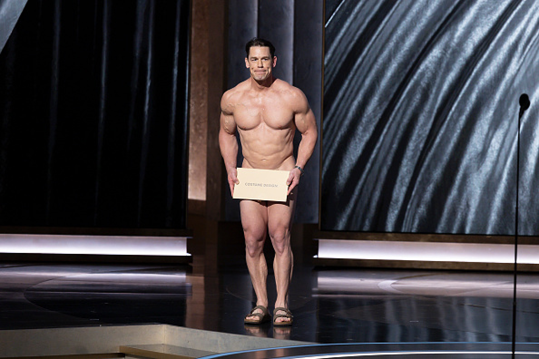 Джон Сина обявява номинациите за Оскар за дизайн на костюми на сцената на Кодак Тиътър. Снимка: Getty Images